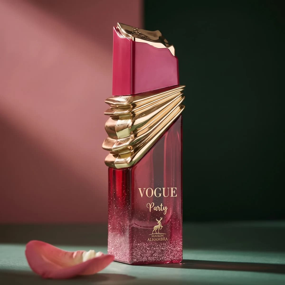 A pink and gold bottle of Maison Alhambra Vogue Party beside a rose petal