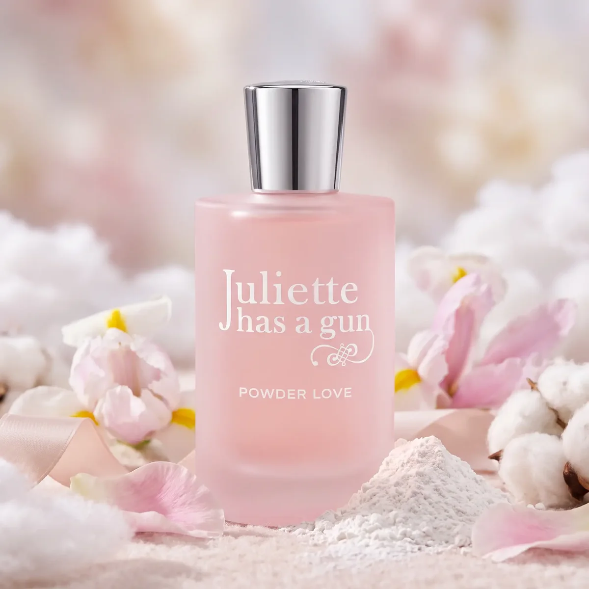 A pink bottle of Juliette Has a Gun Powder Love on soft white powder and cotton flowers
