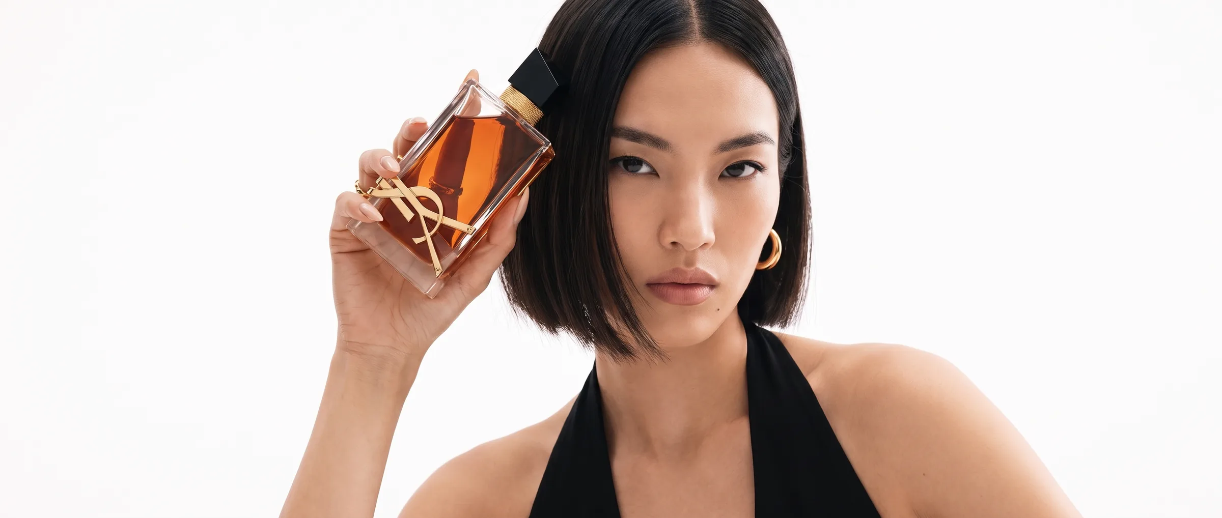 A woman holding a bottle of Yves Saint Laurent Libre Eau de Parfum beside her face